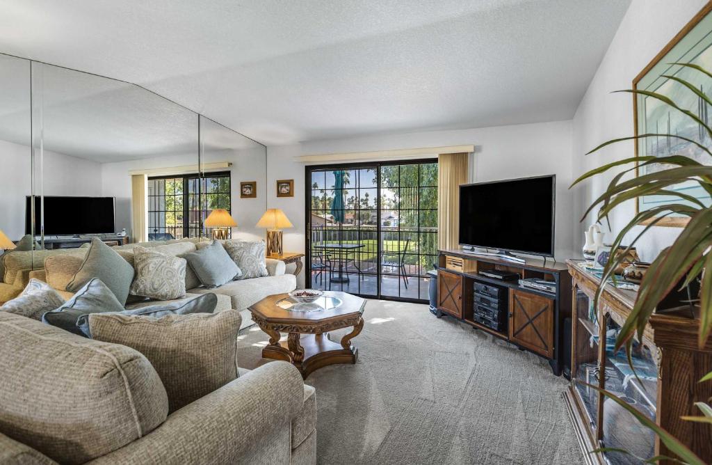 a living room with couches and a flat screen tv at Stylish Condo with Private Pool & & Panoramic View in Palm Springs