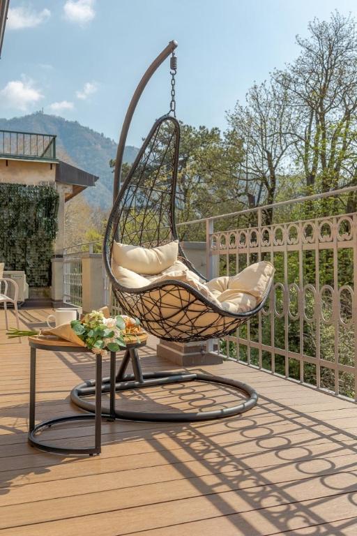a swing chair on a deck with a table at Green Terrace in Cernobbio center in Cernobbio