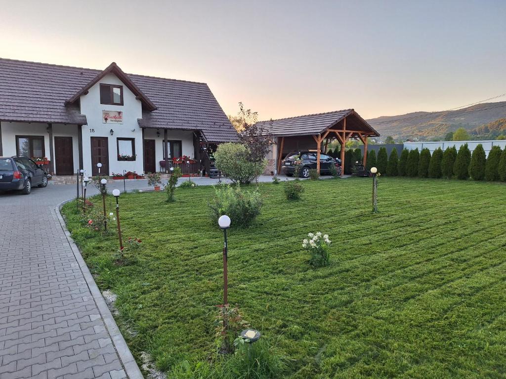 a garden in front of a house with flowers at Casa Muskátli Vendégház in Sovata