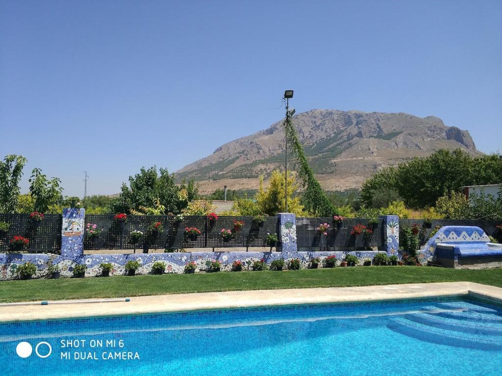 ein Swimmingpool mit einem Berg im Hintergrund in der Unterkunft Parada del Herrero casa rural in Zújar