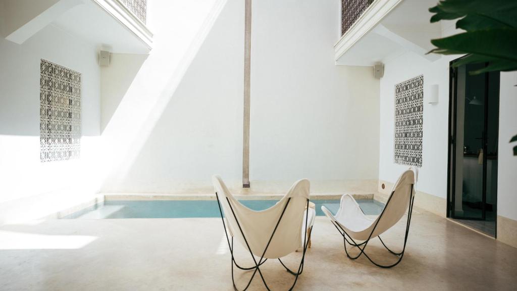 a dining room with two chairs and a table at Riad Dar Mimi in Marrakech