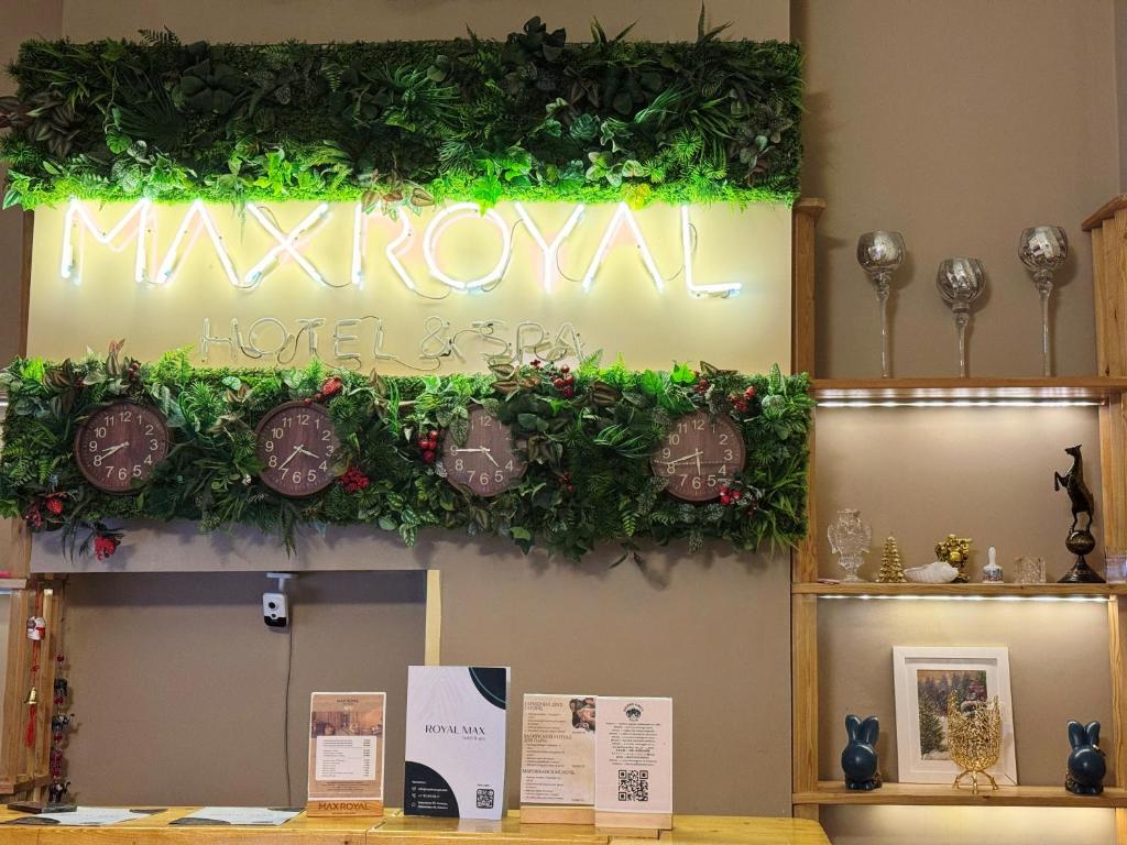 アルマトイにあるRoyal Max hotel & spaの緑のツタが絡まった壁の看板