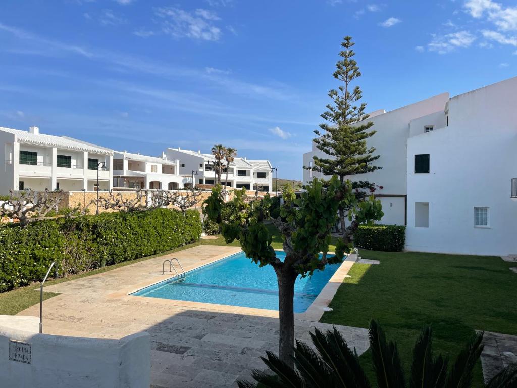 a villa with a swimming pool next to a building at SA PUNTA GRAN A2 by SOM Menorca in Fornells