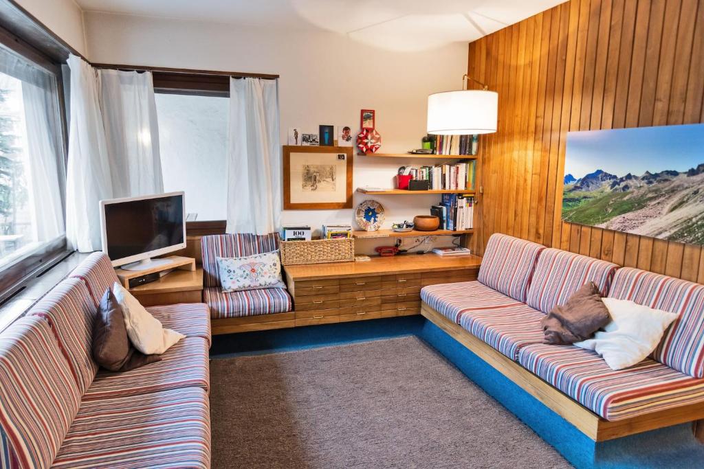 a living room with two couches and a television at Chesa San Gian ground floor - Celerina in Celerina