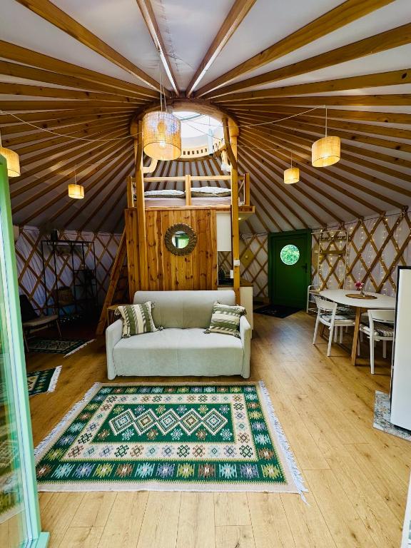 a living room with a couch in a yurt at Szumi Brzoza in Osieczek Piwnice