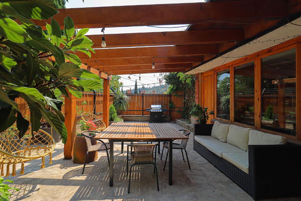 un patio con sofá, mesa y sillas en Luxury Tbilisi House with Garden - by Wehost, en Tiflis