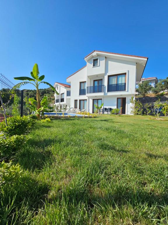 a white house with a lawn in front of it at Asiyan Villas in Marmaris