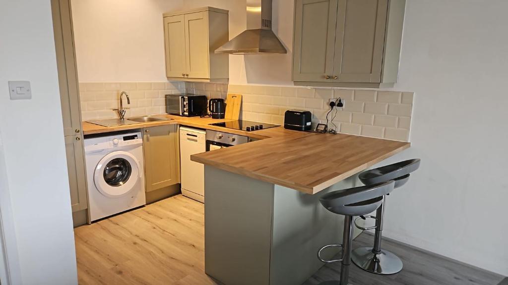 a kitchen with a counter and a washer and dryer at Sea view two bedroom apartment in Hastings