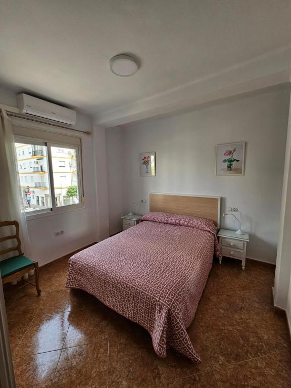 Un dormitorio con una cama con una manta roja y una ventana. en Casa Moli Ronda Parking gratis, en Ronda