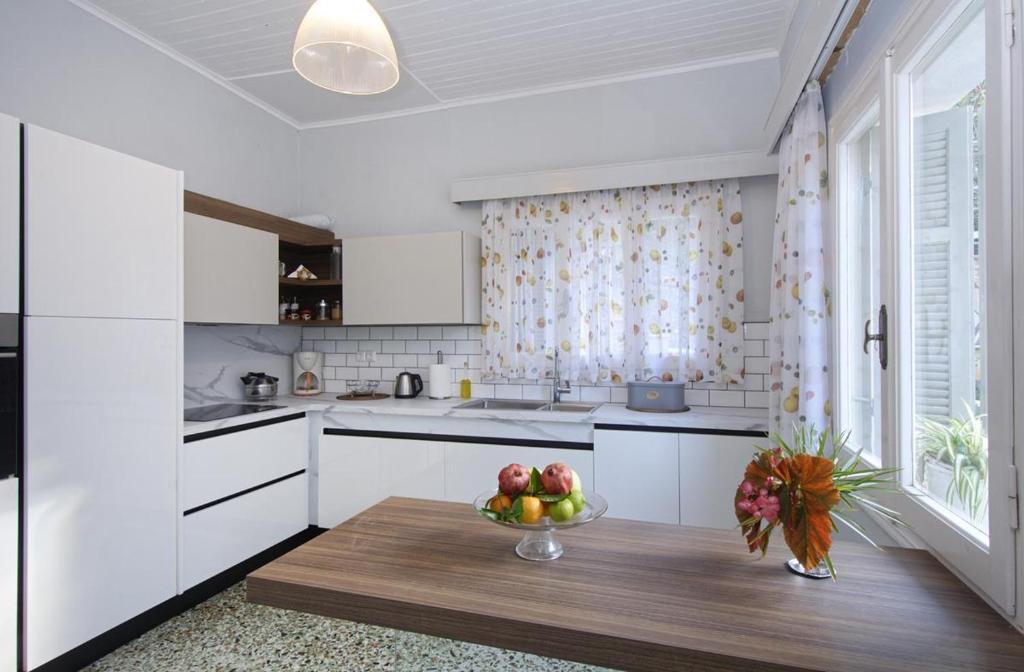 a kitchen with a table with a bowl of fruit on it at Panos Apartments in Gaios