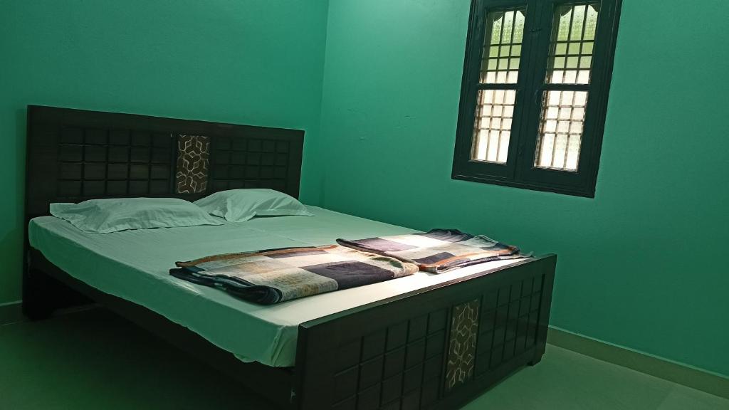 En eller flere senge i et værelse på Kasthuri Guest House