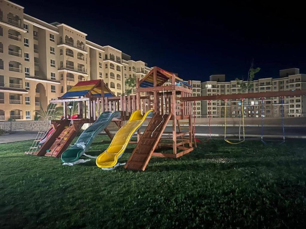 ein Spielplatz vor einem großen Wohnhaus in der Unterkunft Studio in Al Alamein city in El Qasaba esh Sharqīya