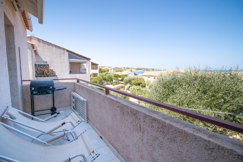 un balcon avec deux chaises et une table sur un immeuble dans l'établissement Scorcio Sull'acqua, à Lumio