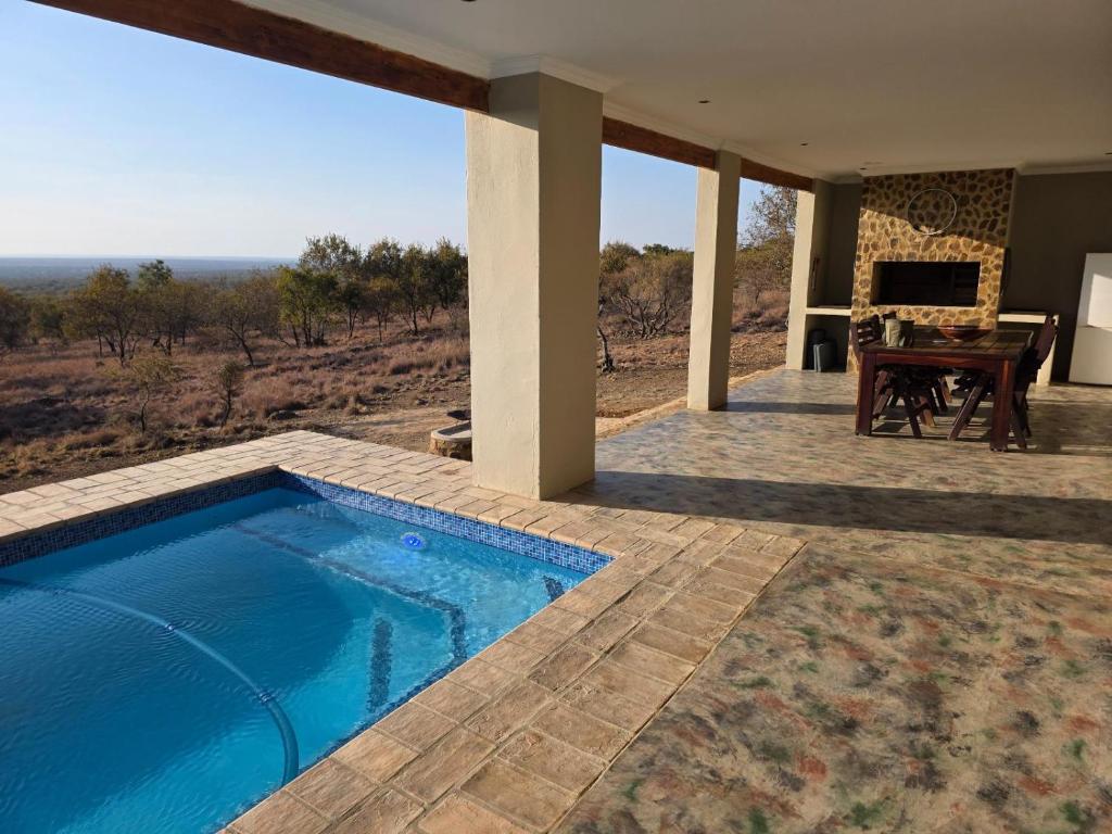 ein Haus mit einem Pool und einem Klavier in der Unterkunft Klipdrift Sands Game Lodge in Dinokeng Game Reserve