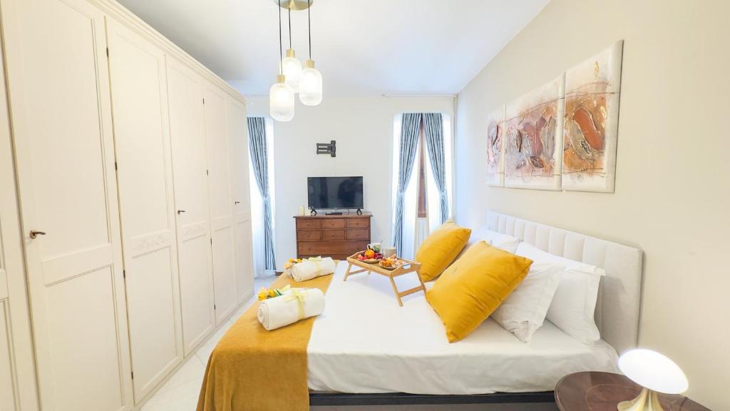 a white bedroom with a bed with yellow pillows at Dimora Sotto le Stelle by Ca-Sa Check in Chioggia