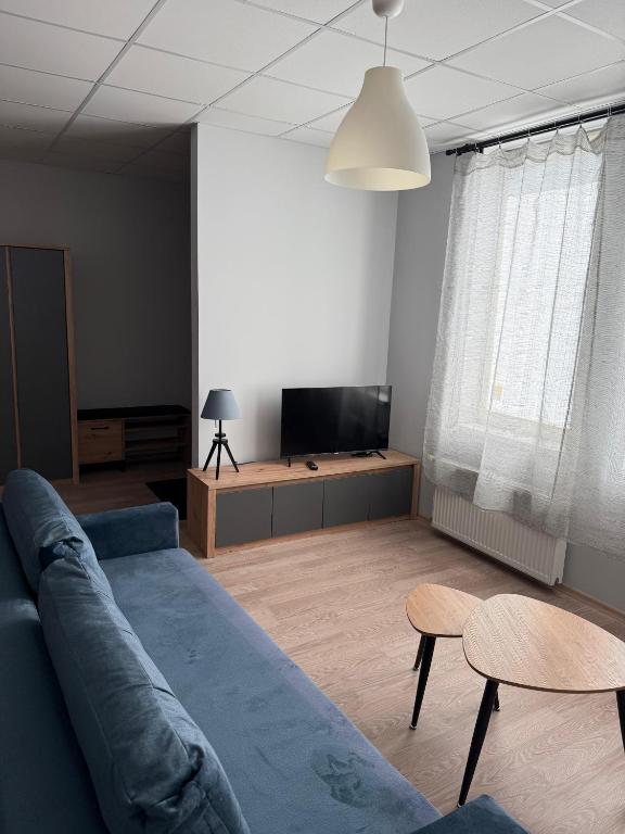 a living room with a couch and a flat screen tv at Apartamenti Upesgrīvā in Upesgrīva