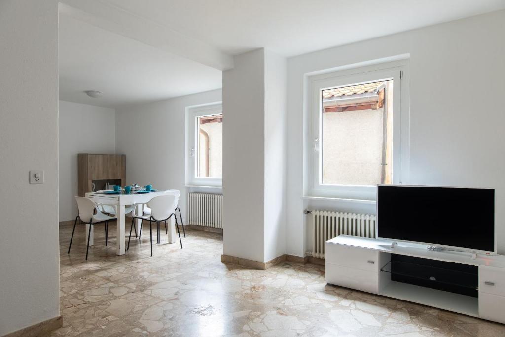 Una sala de estar con un televisor y una mesa. en Rose 2 Apartment by Quokka 360 - duplex on 2 floors with balcony, en Ruvigliana