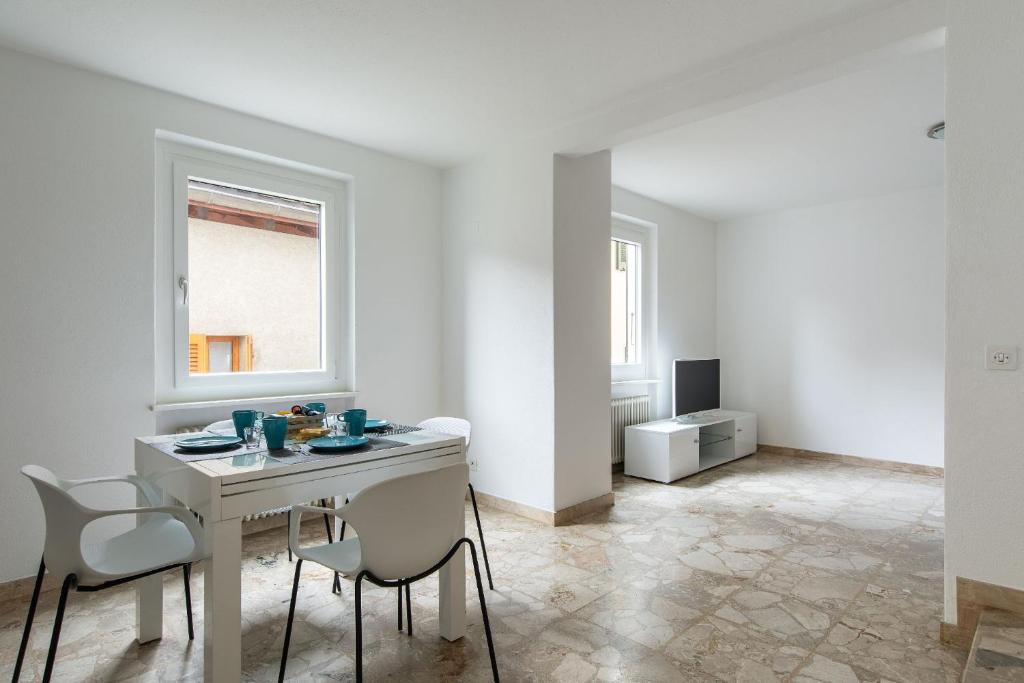 Un comedor blanco con una mesa y sillas. en Rose 2 Apartment by Quokka 360 - duplex on 2 floors with balcony, en Ruvigliana
