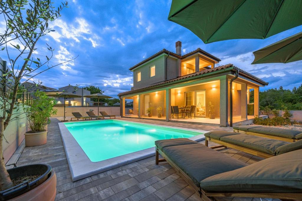 a house with a swimming pool in front of a house at Villa Casa della Capra by Istrialux in Foli