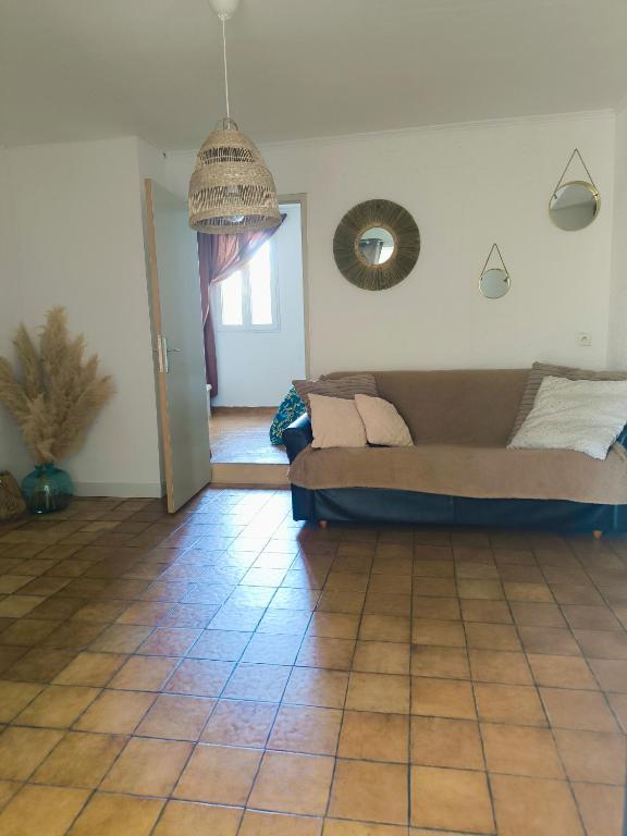 - un salon avec un canapé et du carrelage dans l'établissement Auravignon, à Sorgues