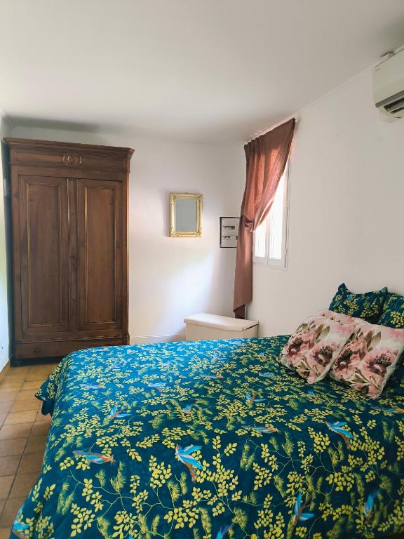 una camera da letto con un letto con un piumone blu di Auravignon a Sorgues