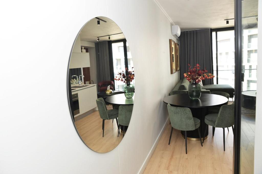 a mirror in a dining room with tables and chairs at Ellipse Olive and Vine in Midrand