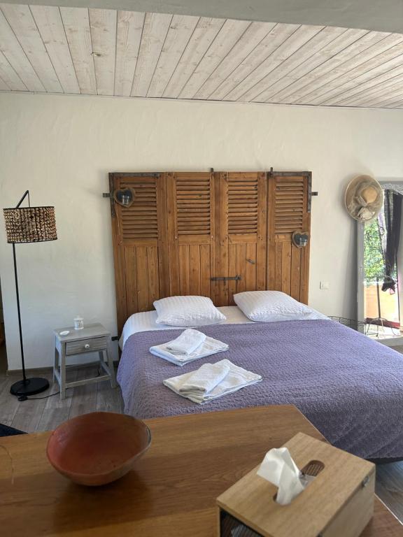 a bedroom with two beds and a wooden headboard at chambre d hôtes les trois châteaux in Notre-Dame-de-Riez