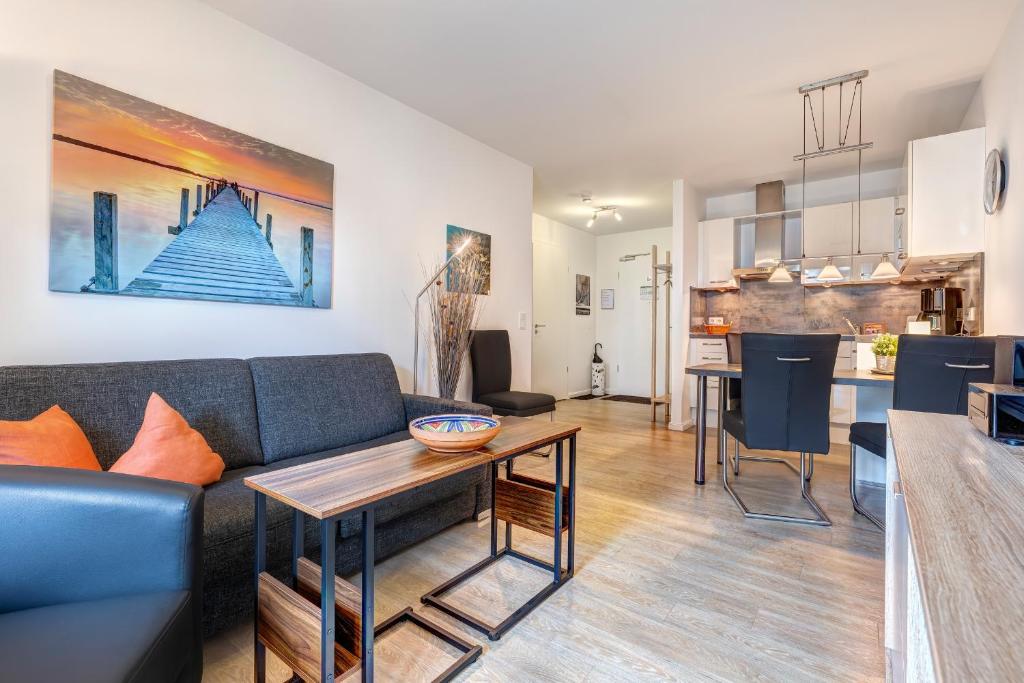 a living room with a couch and a table at Residenz am Balmer See - BS 10 mit Wellnessbereich in Balm