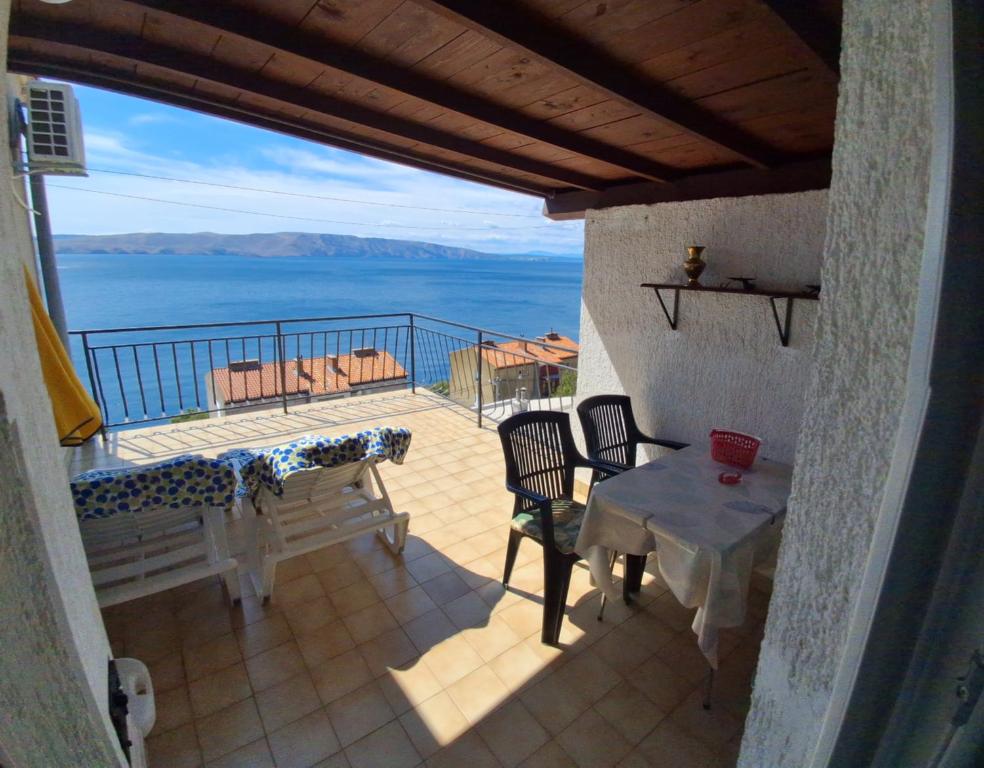 a balcony with a table and chairs and a view of the ocean at Apartment Ana in Senj