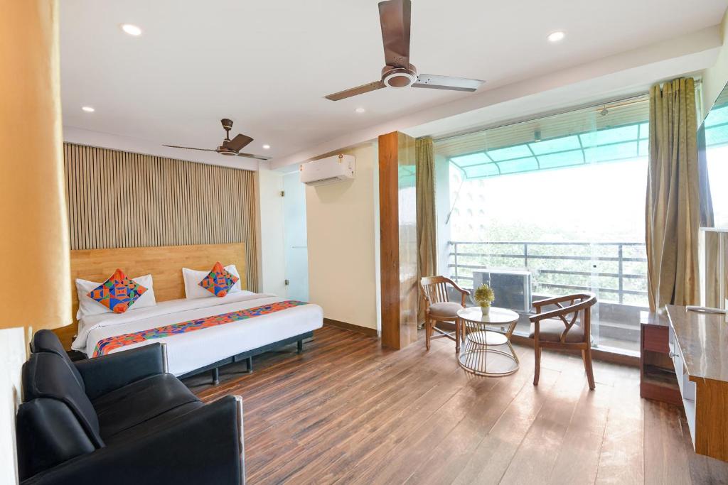 Un dormitorio con una cama y una mesa y sillas. en FabExpress Hari Nagar Ashram, en Nueva Delhi