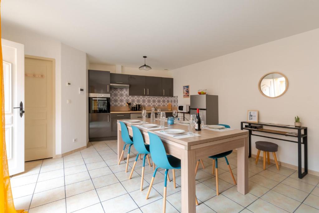 a kitchen with a long table and blue chairs at Superbe Duplex au cœur de la vallée d'Ossau in Izest