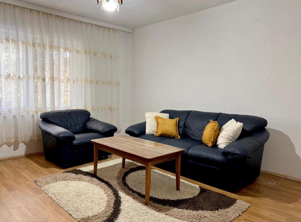 a living room with a blue couch and a coffee table at Podujeva - Home Sweet Home in Orllan