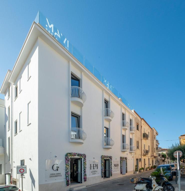 a white building with a sign on the side of it at Hotel Palazzo Antonietta in San Marco di Castellabate