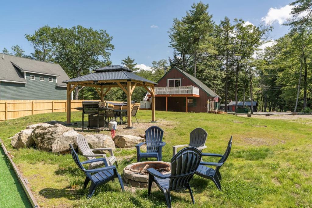 a group of chairs and a fire pit in a yard at 2 Homes Retreat Game Rooms & Fire Pit Winni in Moultonborough