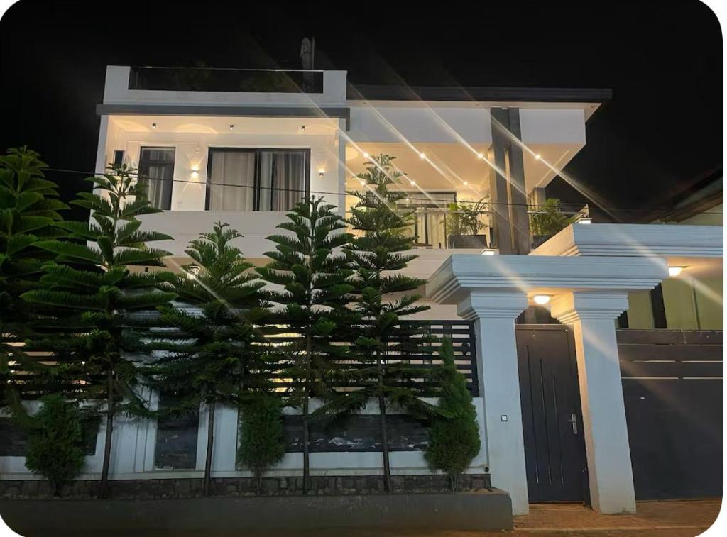 una casa blanca con un árbol delante en Kigali Luxury Home, en Kigali