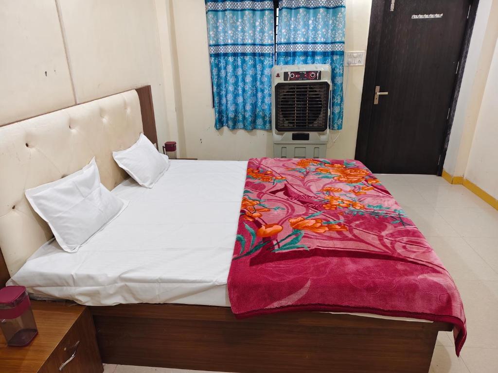 a bedroom with a bed with a blanket on it at Dev Kripa Geust House in Ujjain
