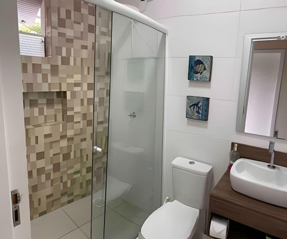 Un baño con ducha, inodoro y lavabo. en 01 - Apto Pé na Areia - Sacada na Praia, en Palhoça