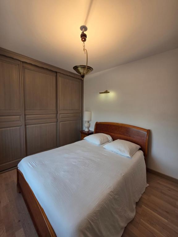 a bedroom with a large bed with two pillows at Chambre Cosy & Vintage - Wifi - TV in Bracquemont