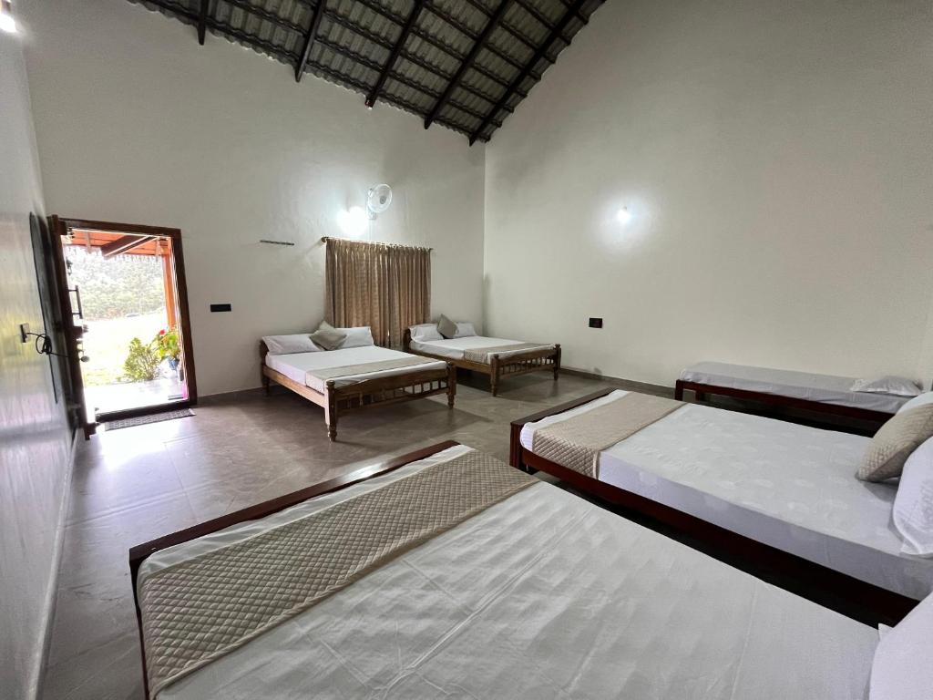 a bedroom with two beds and a living room at Kavalubare Retreat by Dazzle Destinations - Private Cottages and Near to City in Chikmagalūr