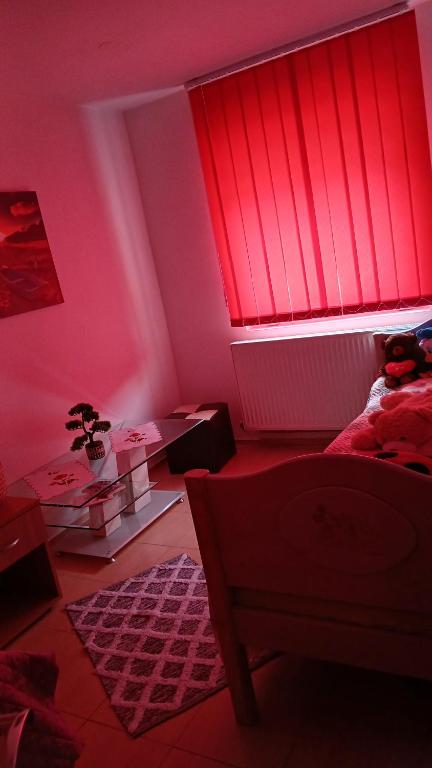 a bedroom with pink walls and a window with red blinds at Apartment boulevard Cetate in Alba Iulia