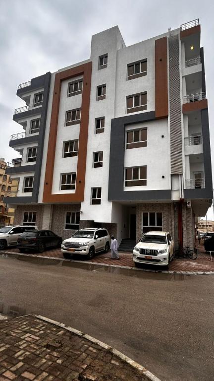 two cars parked in front of a building at Luxury Furnished Apartment in Salalah Center in Salalah