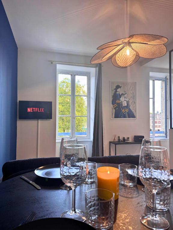 a table with wine glasses and a candle on it at Vue Odet - calme & lit Queen Size à Quimper in Quimper