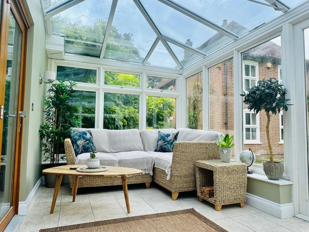 EythorneにあるWisteria Lodge, beautiful home in a great locationのソファとテーブル付きのコンサバトリー