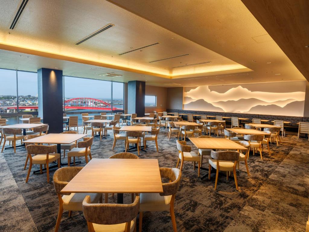 une salle à manger avec tables, chaises et fenêtres dans l'établissement KAMENOI HOTEL Oarai, à Ōarai