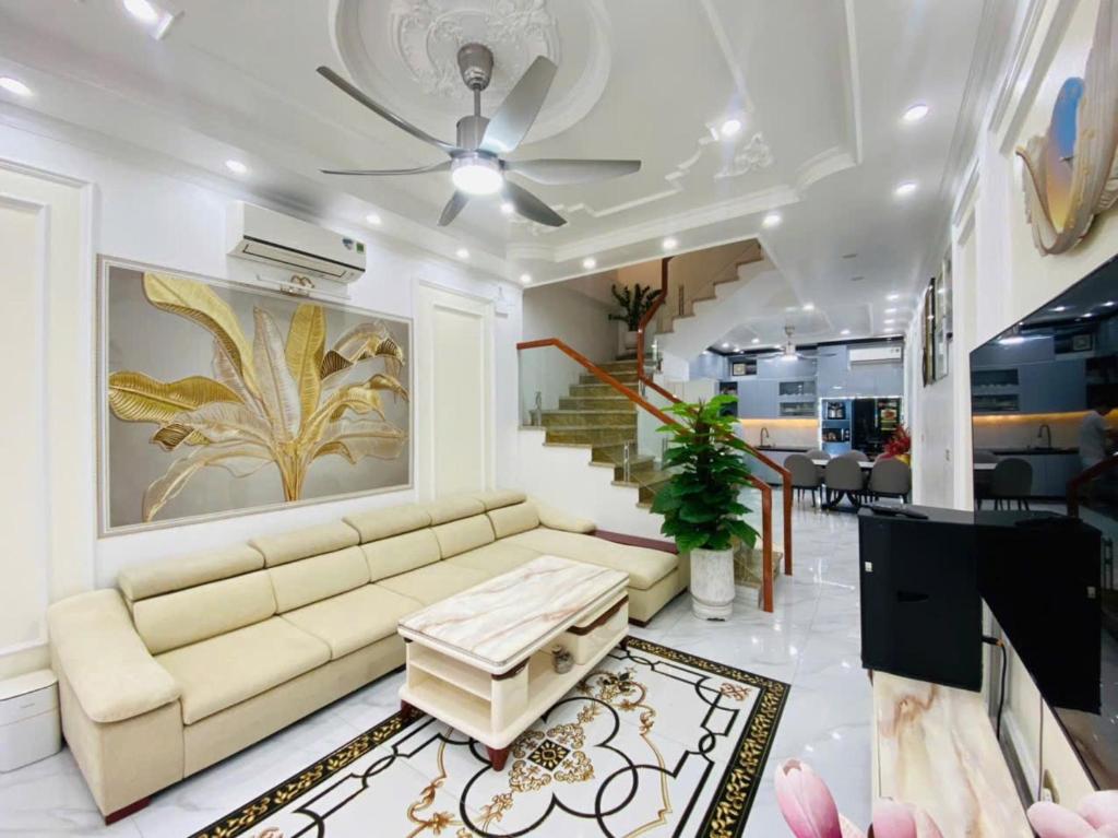 a living room with a couch and a staircase at Happy Hou'se in Cat Ba