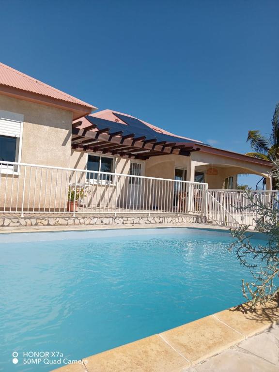 a swimming pool in front of a house at Leu doux bruit des vagues in Saint-Leu