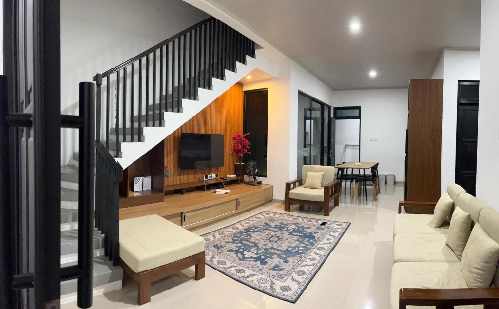 a living room with a staircase and a television at Majid's Homestay Solo in Kartosuro