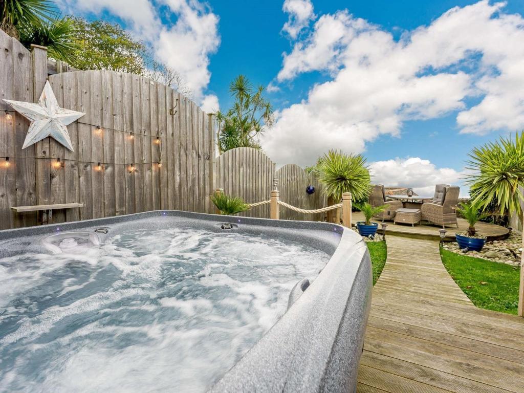 a hot tub in a backyard with a wooden fence at 2 Bed in Ventnor 90147 in Ventnor