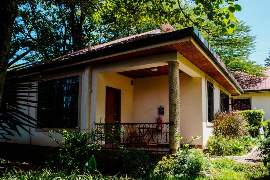 a small house with a porch and a balcony at Falcon Heights Hotel in Nanyuki