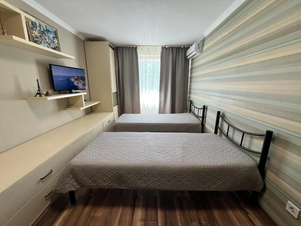 two beds in a small room with a window at Seven Apartments 62 in Vyshneve